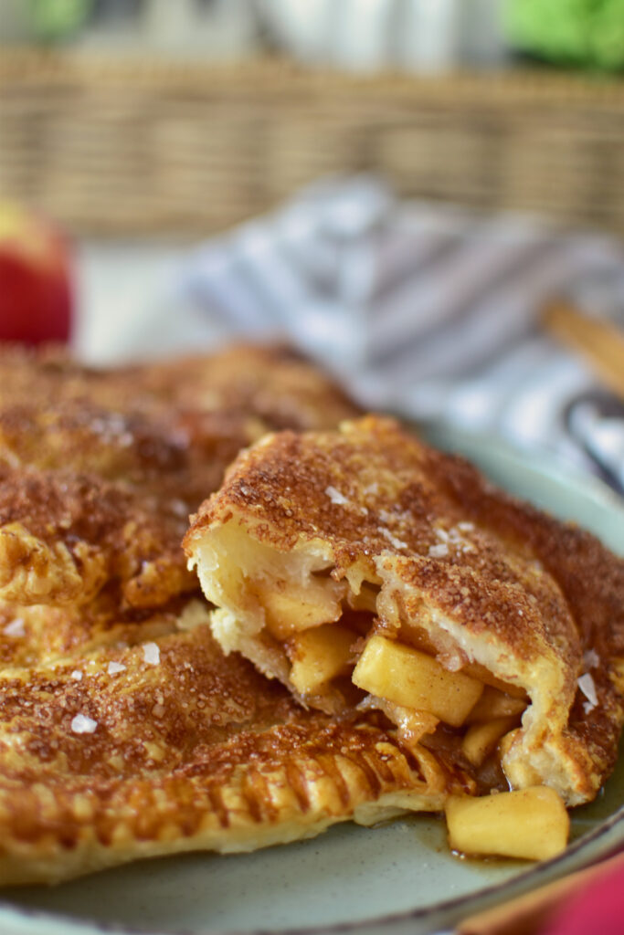 Detailfoto vom süß gefüllten Blätterteig aus dem Airfryer mit warmer Apfel-Zimt-Füllung, die man im Anschnitt sehen kann.