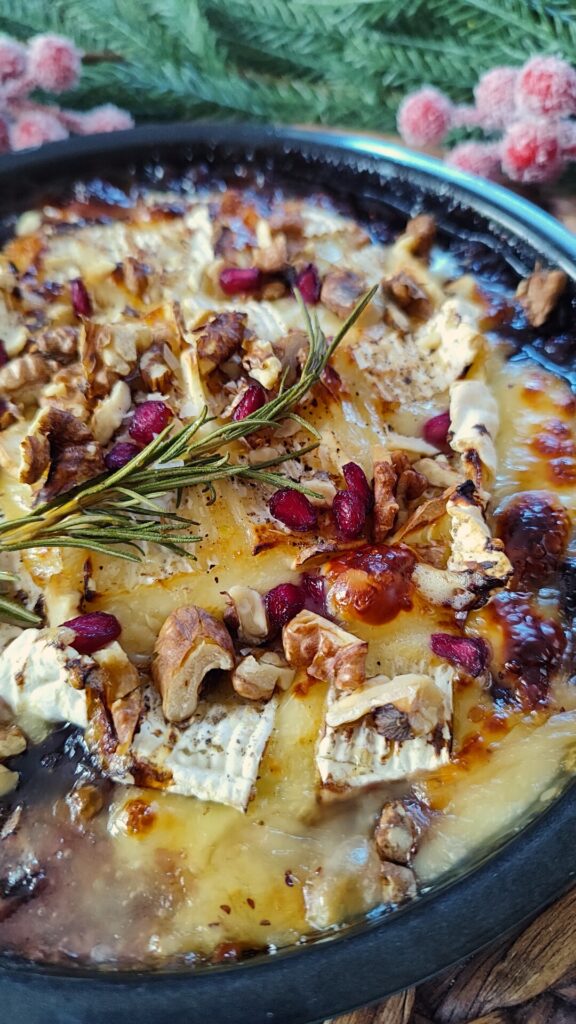 Gebackener Camembert mit warmer Preiselbeersauce und goldbraun geschmolzenem Käse als Nahaufnahme.